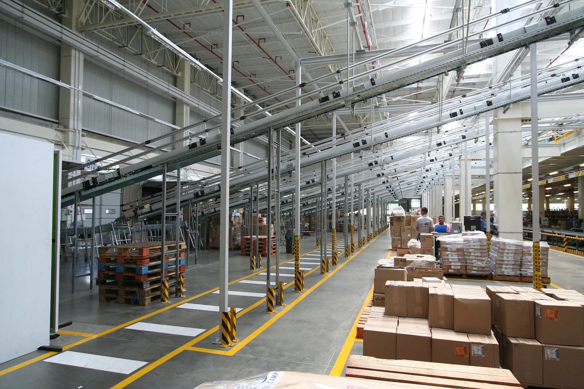 Interior del centro de distribución Avon Natura en Guarne, Antioquia. Sistema de transporte de mercancías con cintas transportadoras y almacenamiento en estanterías. Servicios de diseño y consultoría logística Dinpro.