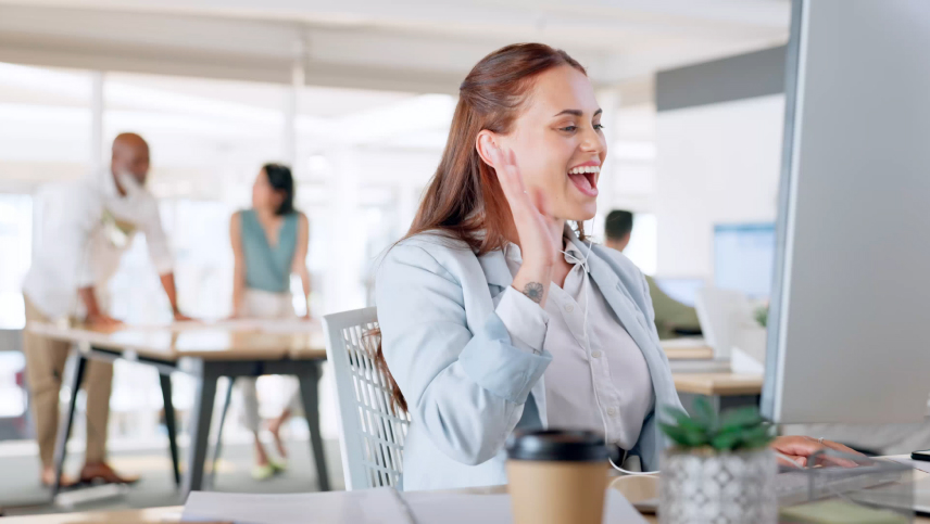 Mujer sonriendo mientras trabaja en la computadora, concepto de reporte confidencial y ética en Dinpro. Ambiente de oficina transparente.