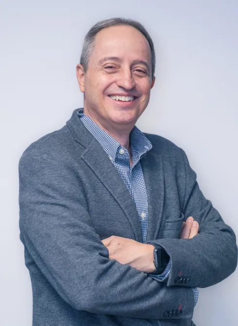 Ingeniero Juan Carlos Molina Correa, Presidente del Grupo Dinpro, sonriendo a la cámara. Líder empresarial con experiencia en proyectos de ingeniería y administración.