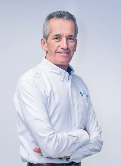 Ingeniero Juan Guillermo Rendón Gómez, Gerente Comercial de Dinpro, sonriendo a la cámara. Retrato profesional de un líder empresarial.
