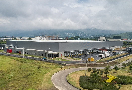 Vista aérea de un moderno centro logístico industrial con camiones y amplias instalaciones, Dinpro ofrece soluciones integrales para el sector logístico.