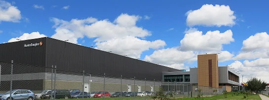 Imagen de un proyecto industrial completado por Dinpro, mostrando una moderna infraestructura y estacionamiento. Soluciones integrales para el sector industrial.