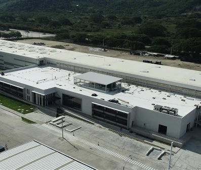 Vista aérea de un proyecto industrial completado por Dinpro, mostrando una moderna edificación con amplias instalaciones y áreas verdes. Desarrollo de proyectos integrales.