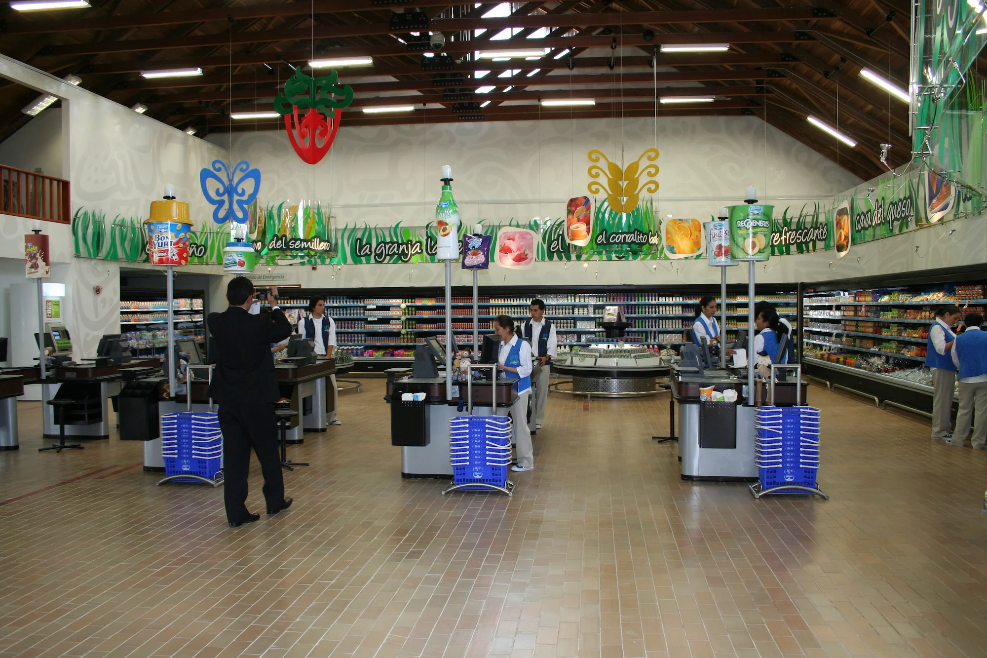 Interior de Cabaña Alpina en Sopó, Cundinamarca. Diseño de arquitectura comercial y retail por Dinpro. Supermercado con cajas registradoras y pasillos de productos.