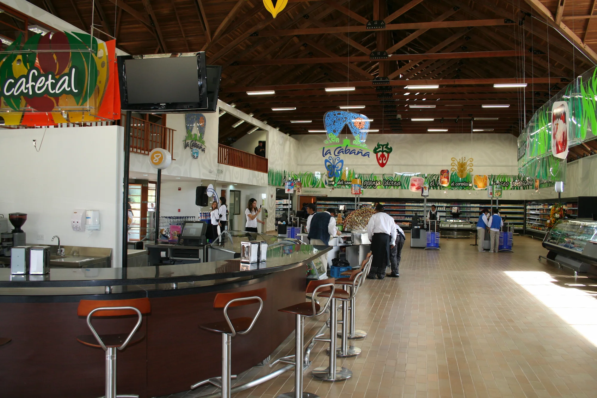 Interior de Cabaña Alpina en Sopó, Cundinamarca, diseño de arquitectura comercial y retail por Dinpro. Tienda con barra de café y productos frescos.