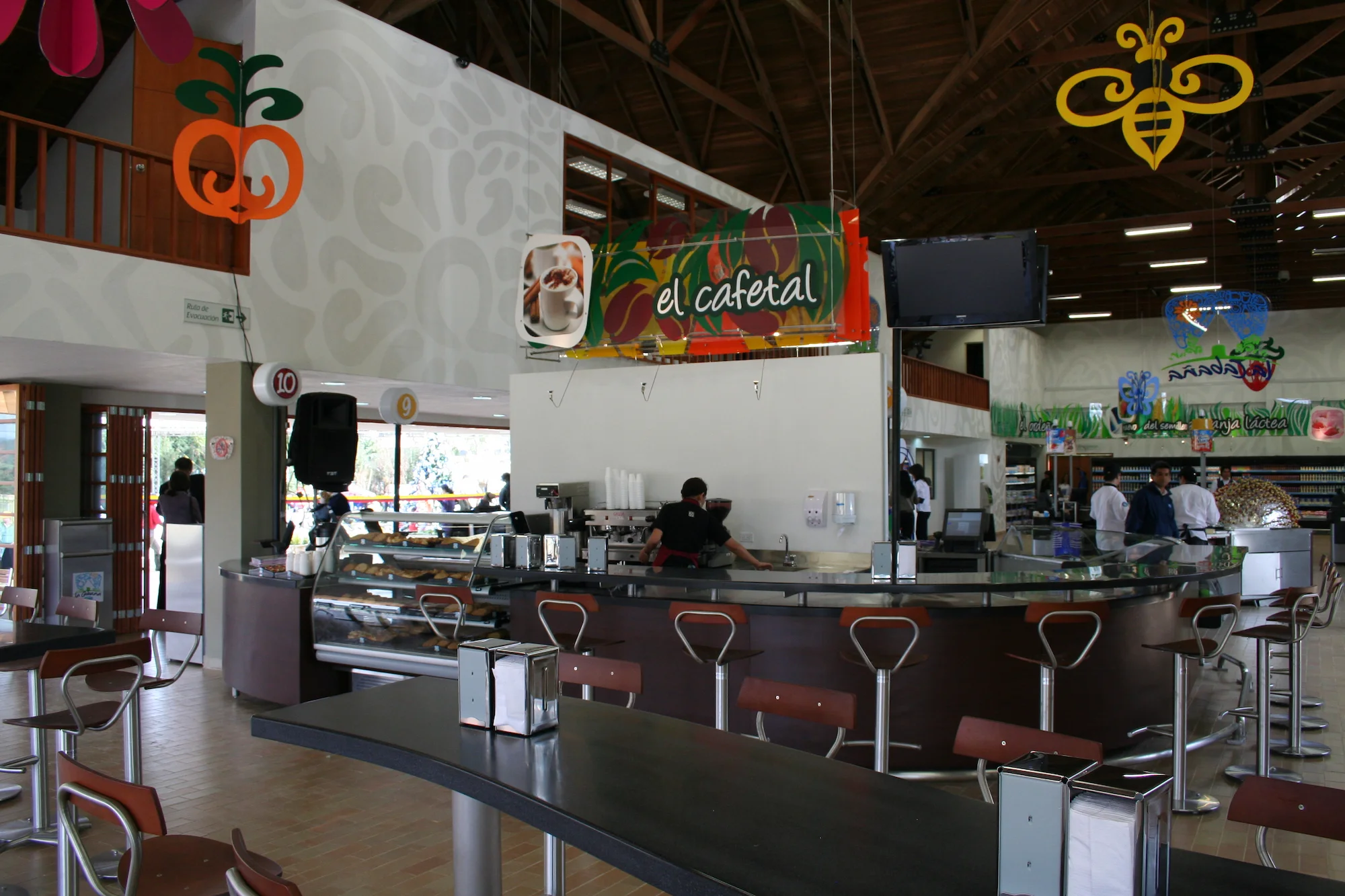 Interior de cabaña alpina con diseño de arquitectura Dinpro en Sopó, Cundinamarca. Espacio comercial tipo cafetería con barra y mesas.